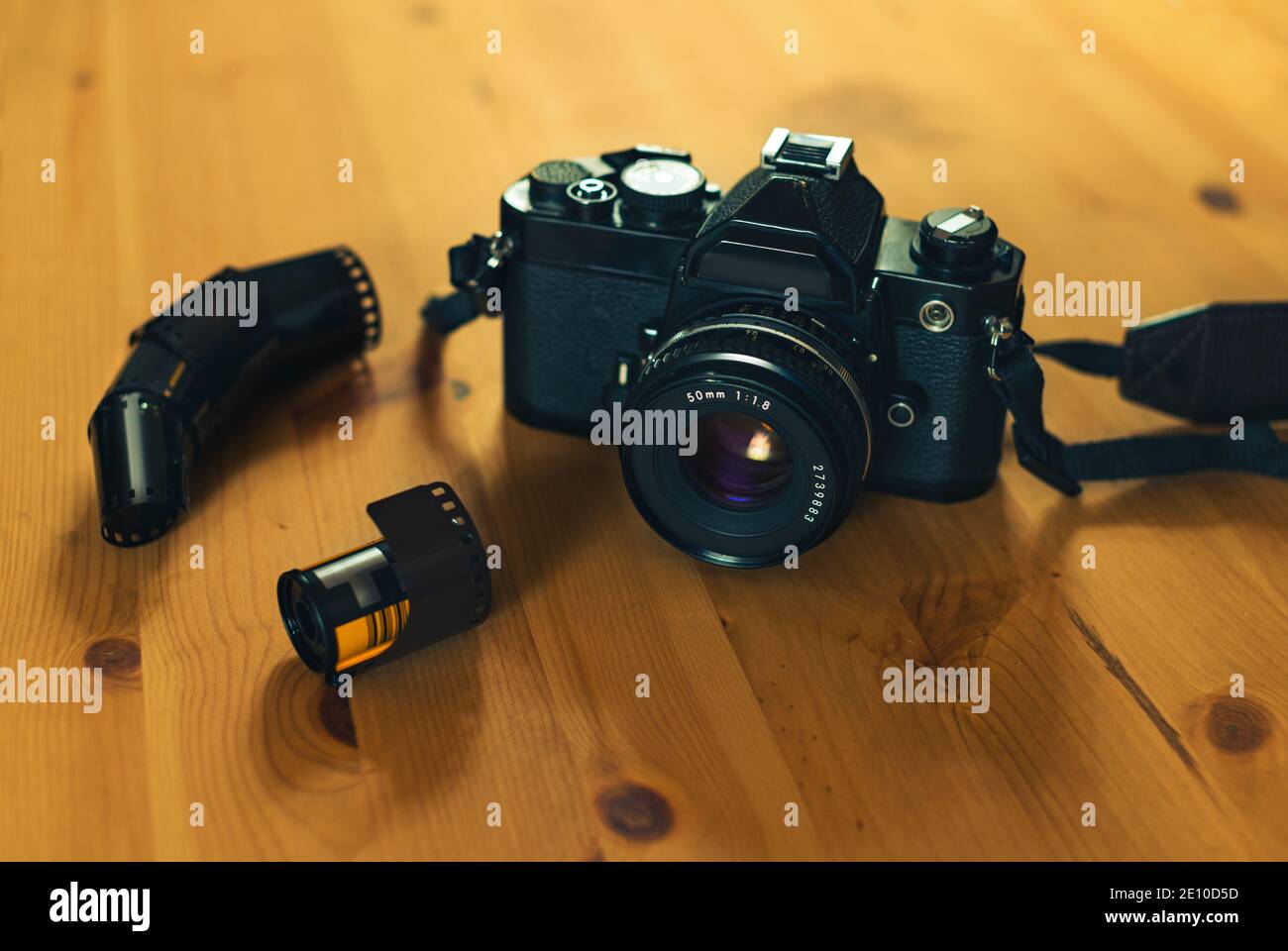 Image fixe d'une caméra analogique avec un film négatif 35 mm sur fond en bois. Banque D'Images