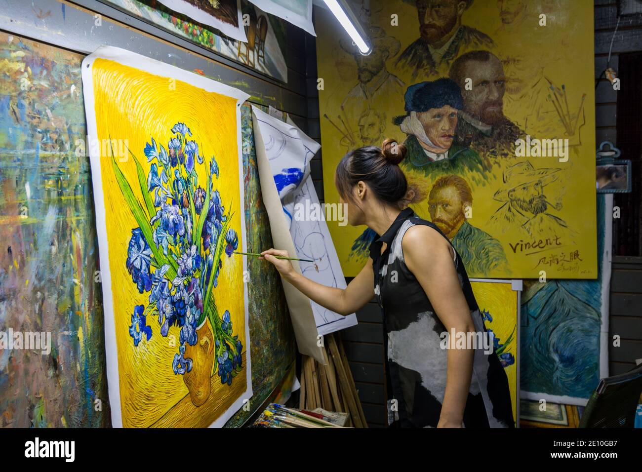 Une peintre féminine peignant un célèbre chef-d'œuvre de Vincent van Gogh dans son studio de Dafen Oil, village de peinture de Shenzhen, en Chine Banque D'Images