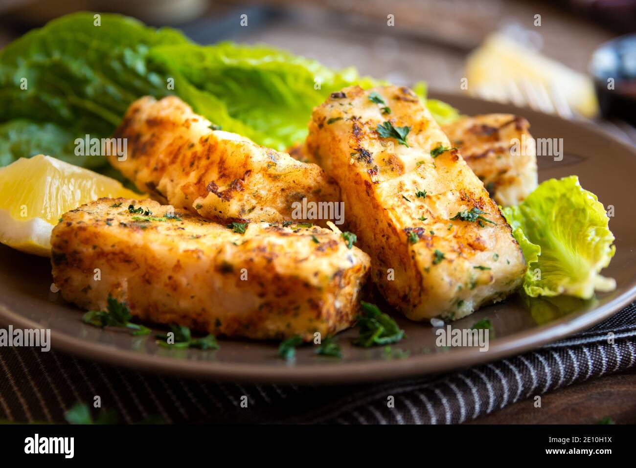 Filet de poisson cuit avec citron et laitue Banque D'Images