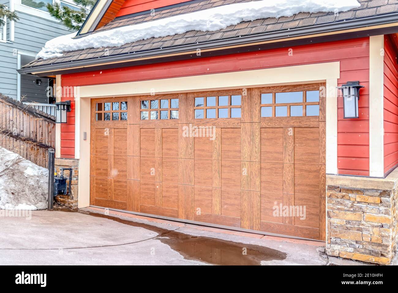 Grande porte de garage en bois avec panneau de verre de la maison avec  rouge et mur extérieur en briques Photo Stock - Alamy