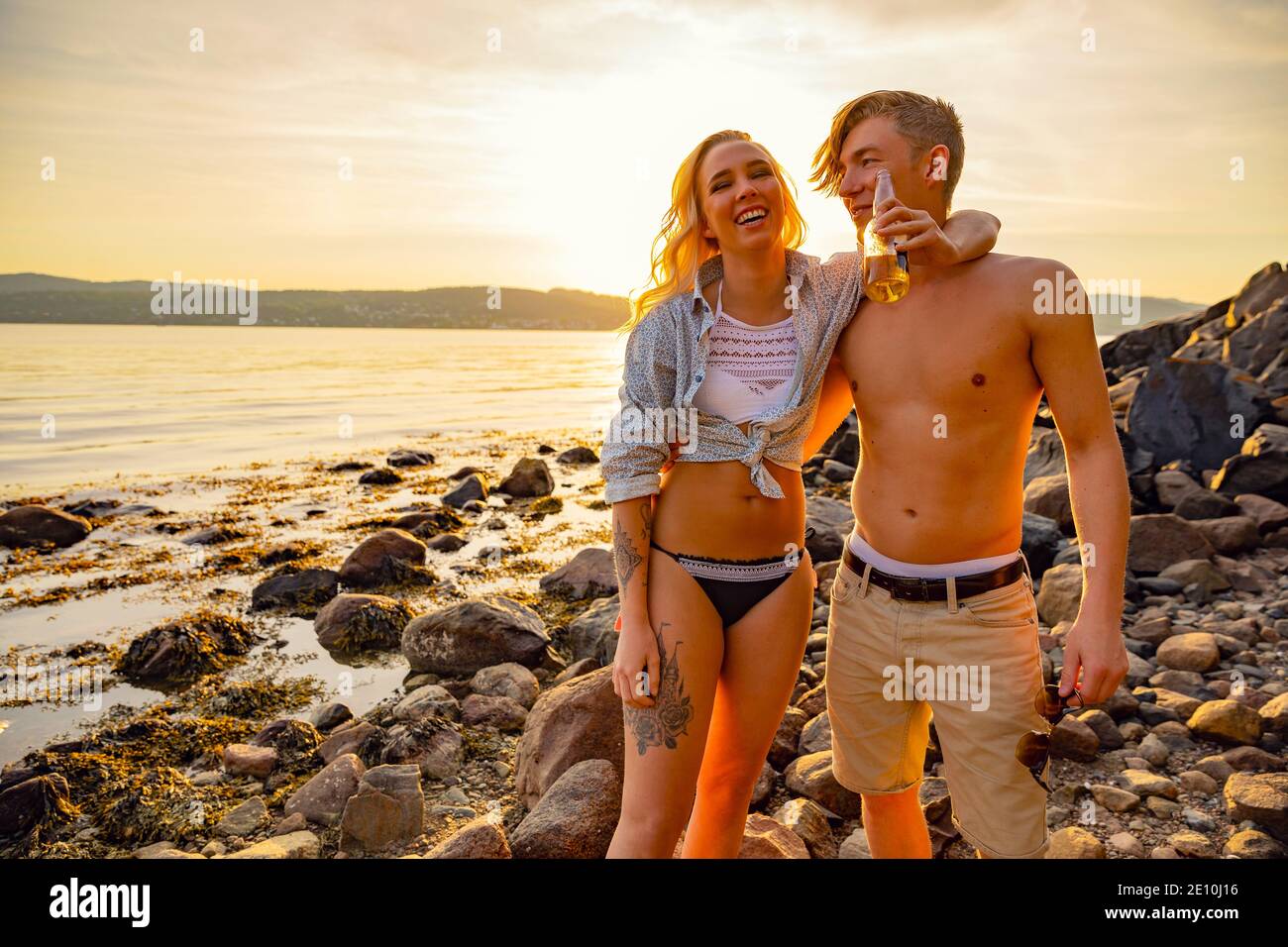 Couple heureux s'amuser et de boire une bière sur la plage Banque D'Images