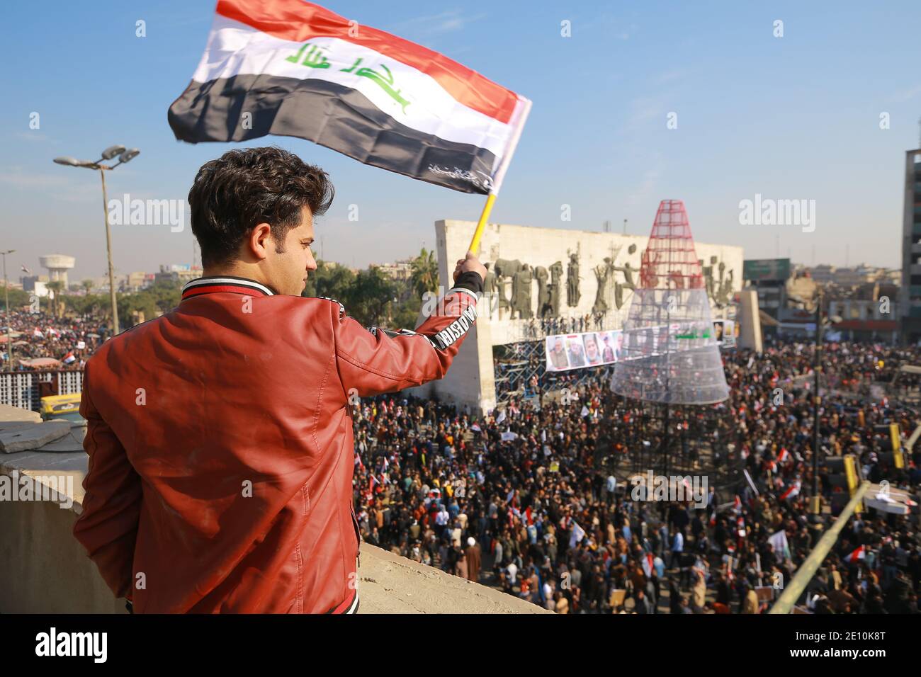 Bagdad, Irak. 03ème janvier 2021. Un irakien garde un drapeau lors d'une manifestation sur la place Tahrir pour commémorer le premier anniversaire de l'assassinat du commandant militaire iranien et chef de ses forces Quds, le général Qasem Soleimani, qui a été tué par une frappe aérienne américaine près de l'aéroport de Bagdad. Credit: Ameer Al Mohmedaw/dpa/Alamy Live News Banque D'Images