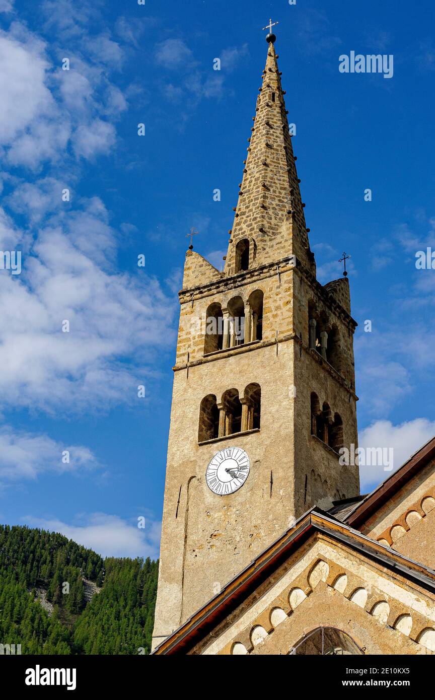 Église typique des Hautes-Alpes. Le clocher est entièrement construit en pierre locale. Le cadran d'une horloge permet à tout le village de connaître l'heure. Banque D'Images