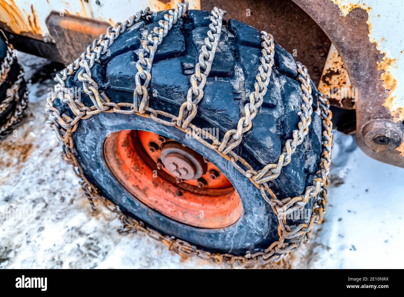 Énorme roue noire d'un bulldozer enveloppée de chaînes rouillées contre la  neige Photo Stock - Alamy