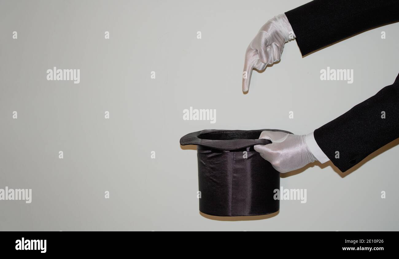 Portrait du jeune magicien noir de l'Ilusionniste faisant de la magie avec un chapeau et baguette magique isolés sur un blanc arrière-plan Banque D'Images