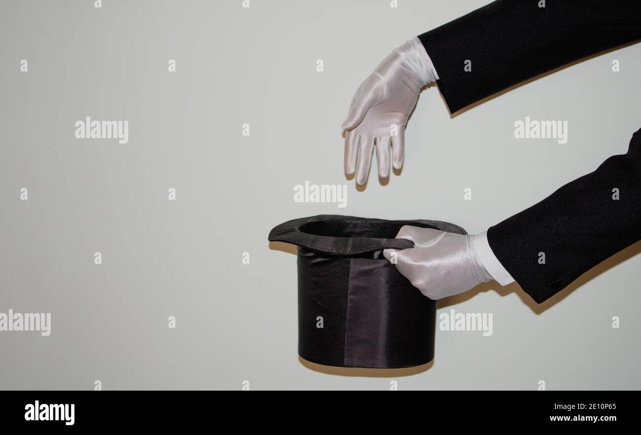 Portrait du jeune magicien noir de l'Ilusionniste faisant de la magie avec un chapeau et baguette magique isolés sur un blanc arrière-plan Banque D'Images