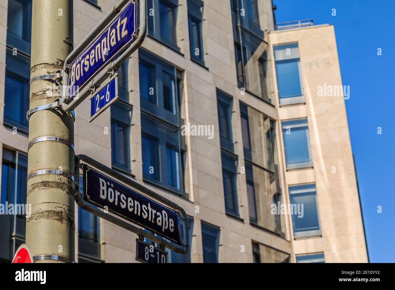 Deux panneaux de rue bleus place de bourse et rue de bourse sur un lampadaire gris avec fixations. Maison avec façade de fenêtre en arrière-plan Banque D'Images