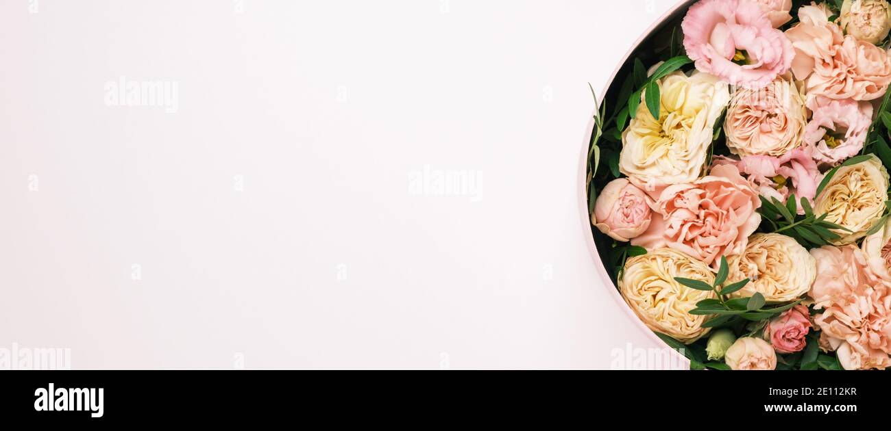 Luxe belles fleurs dans un chapeau rond boîte sur le fond rose avec espace de copie. Cadeau ou cadeau le jour de la Saint-Valentin, 8 mars, fête des mères Banque D'Images