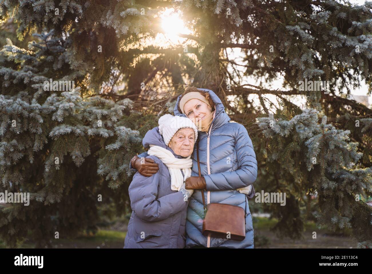 Couple de femmes d'âge mûr caucasien et de femmes âgées sont heureux de passer du temps sur les vacances de Noël et de nouvel an ensemble, souriant et embrassant dans la forêt Banque D'Images