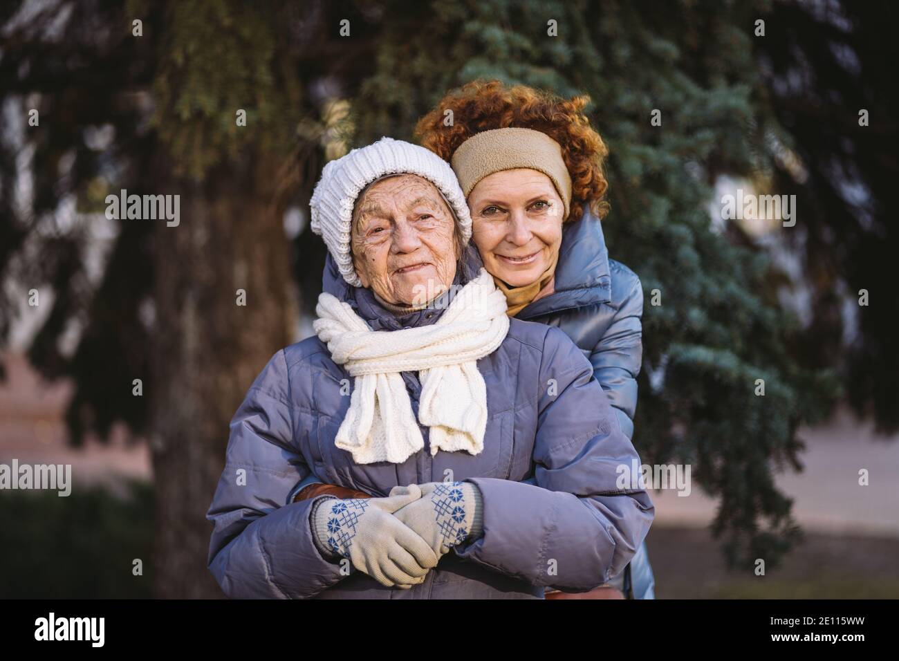 Couple de femmes d'âge mûr caucasien et de femmes âgées sont heureux de passer du temps sur les vacances de Noël et de nouvel an ensemble, souriant et embrassant dans la forêt Banque D'Images