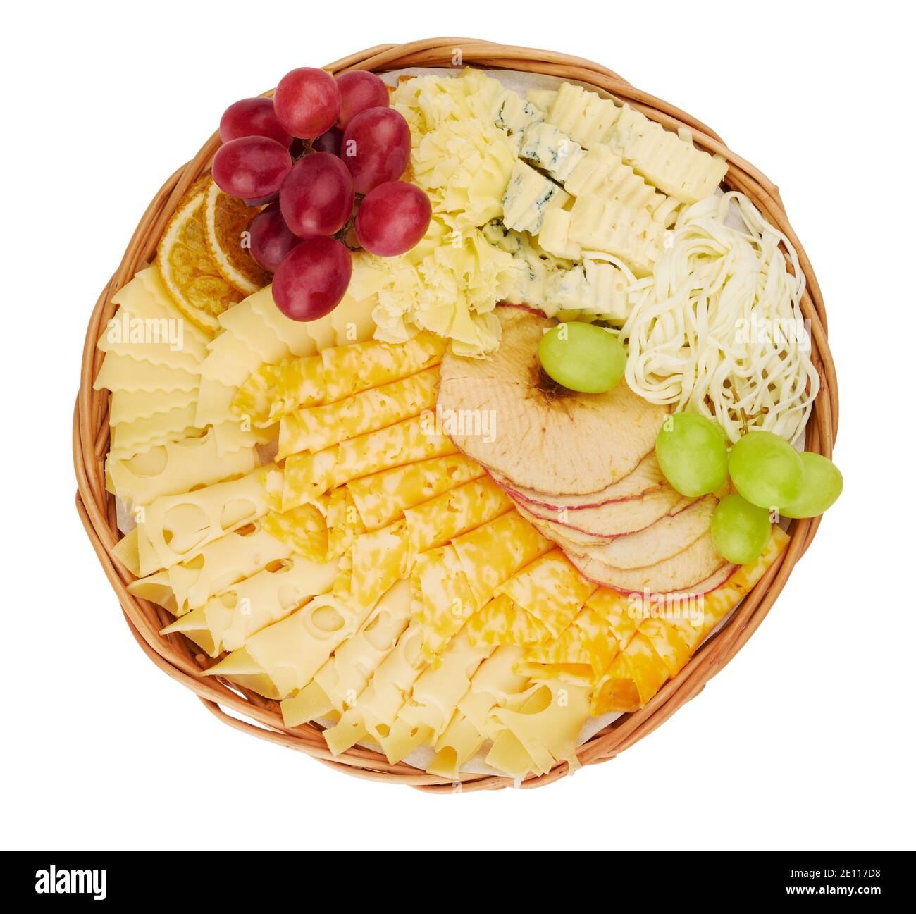 Panier plat en osier avec un délicieux assortiment de fromages, tranches d'orange séchées, pommes séchées, raisins isolés sur fond blanc Banque D'Images