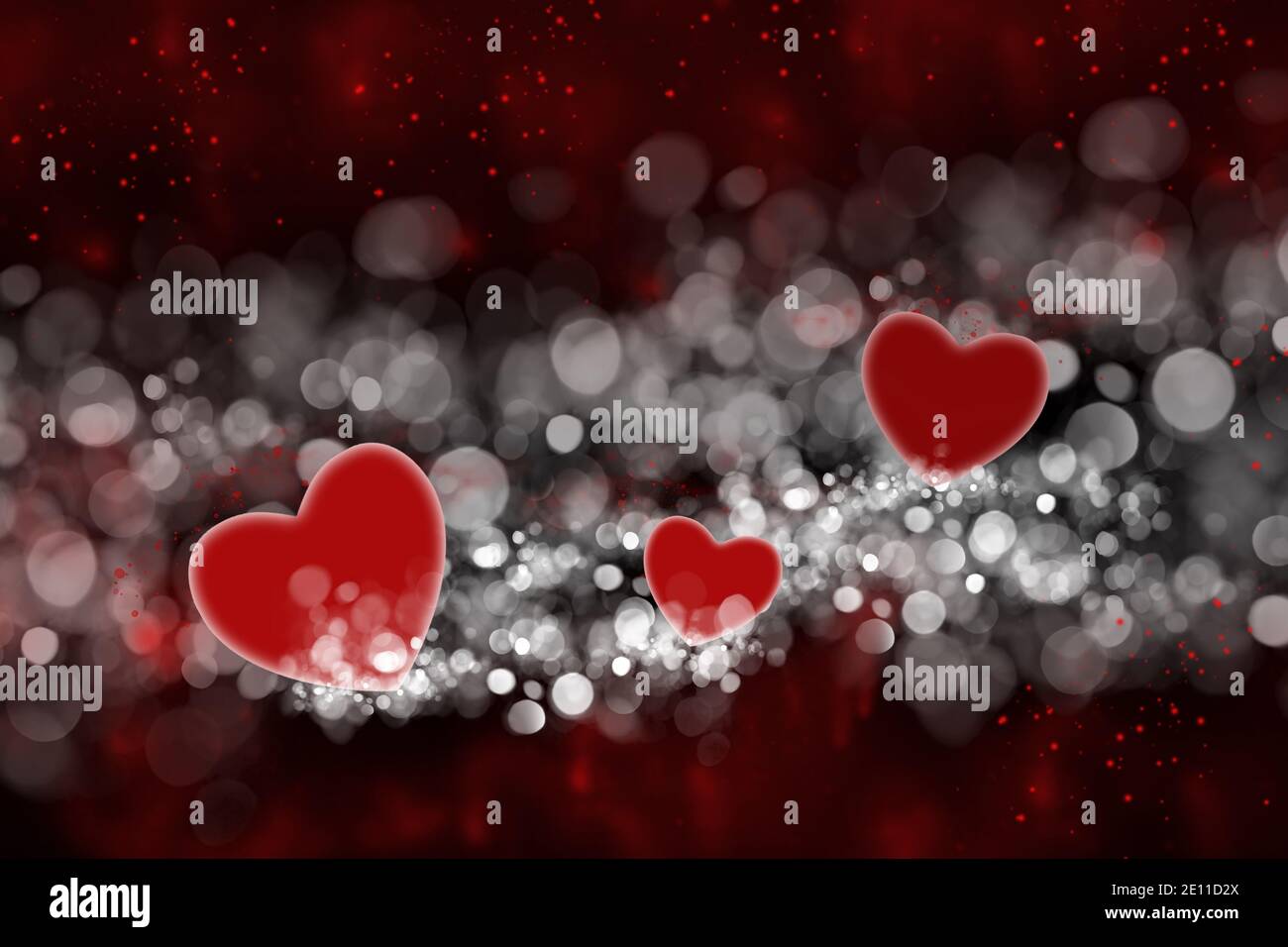 Coeurs rouges et bokeh blanc sur fond noir. Saint Valentin. Un arrière-plan romantique et abstrait. Banque D'Images