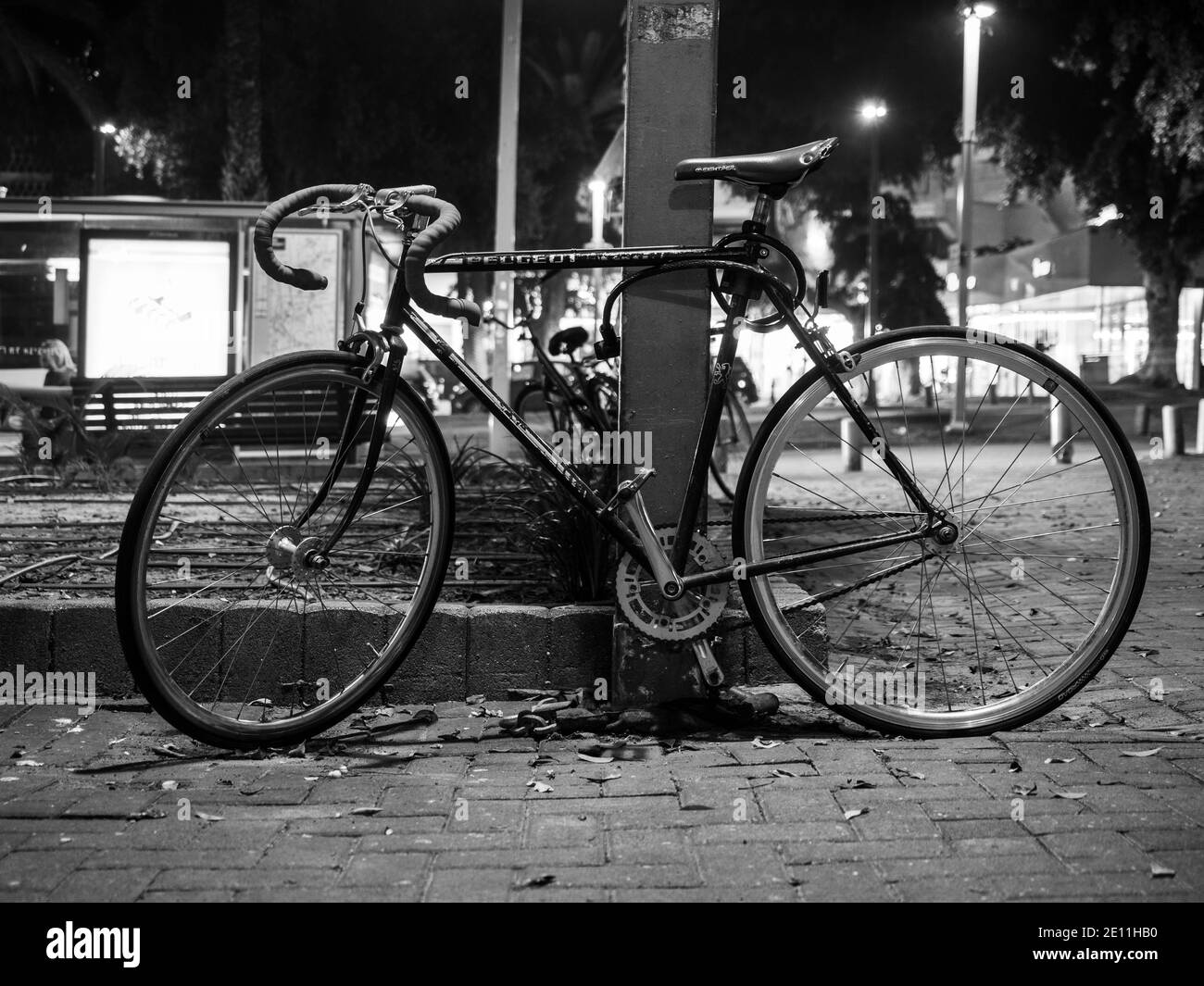 Vieille route de style vélo de ville à vitesse unique parking vélo la nuit sur la chaussée de la ville. Banque D'Images