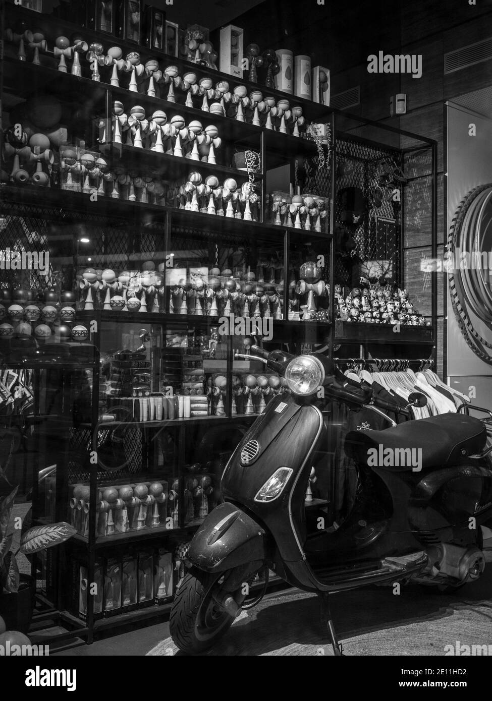 Une boutique moderne avec des outils de jonglage exposés sur des étagères et un scooter VESPA devant Banque D'Images