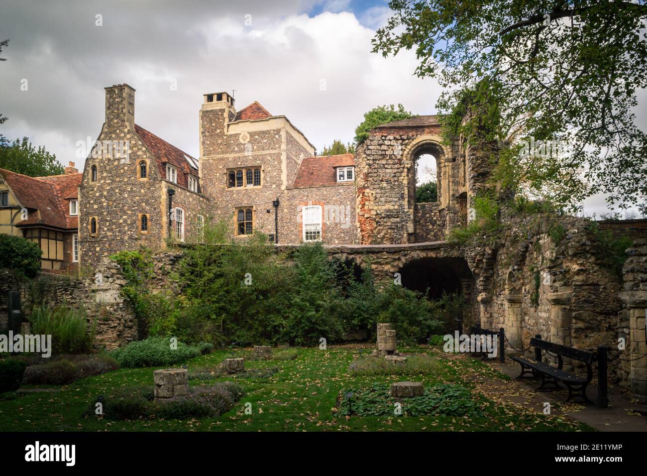 CANTERBURY, ANGLETERRE - 18 OCTOBRE 2018: Deux bancs dans un jardin d'herbes sur le terrain de la cathédrale de Canterbury en automne, surplombée par quelques maisons anciennes Banque D'Images