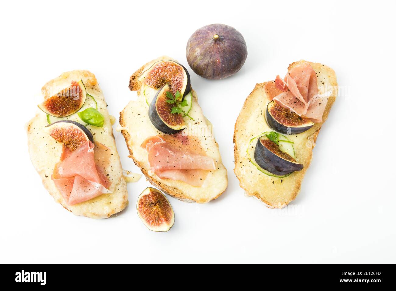 Pain au jambon et au fromage cuit recouvert de figues, fond blanc, vue de dessus Banque D'Images