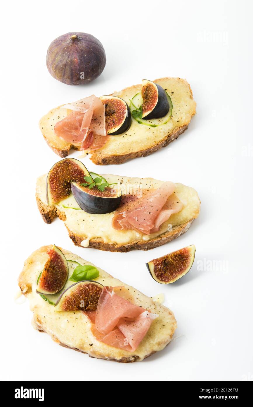 Pain au jambon et au fromage cuit recouvert de figues, fond blanc, vue de dessus Banque D'Images