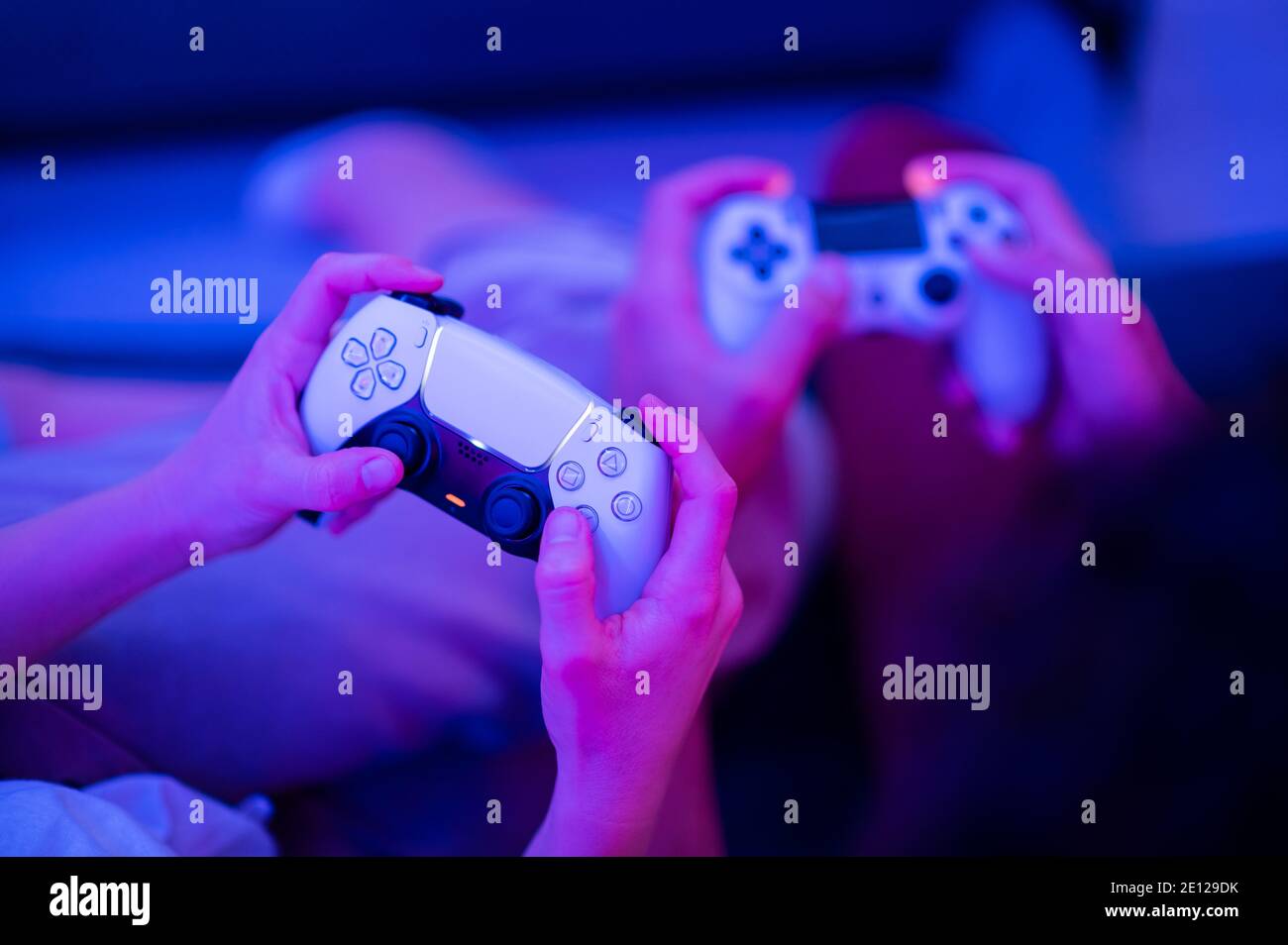 Fille utilisant la nouvelle manette sans fil DualSense PlayStation 5 de Sony qui offre un retour haptique immersif, des déclencheurs dynamiques adaptatifs et un intégré Banque D'Images