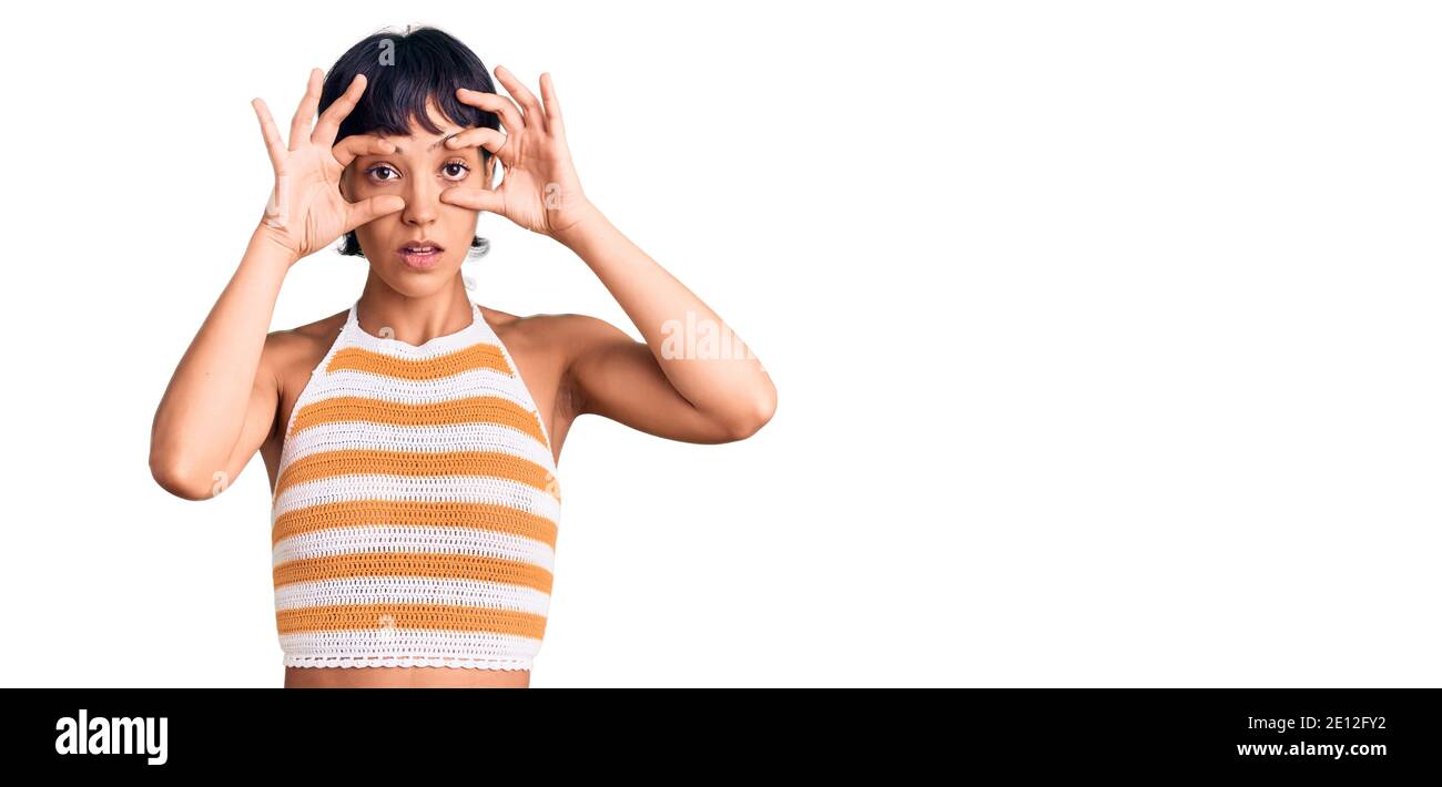 Jeune femme brune aux cheveux courts portant des vêtements décontractés essayant d'ouvrir les yeux avec les doigts, endormie et fatiguée pour la fatigue matinale Banque D'Images