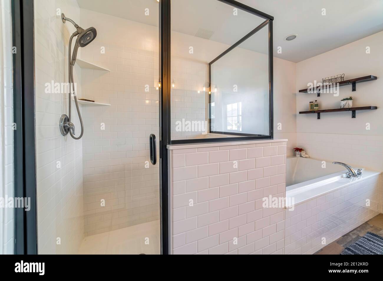 Cabine de douche en verre et baignoire intégrée dans la salle de bains avec  mur blanc et carrelage Photo Stock - Alamy