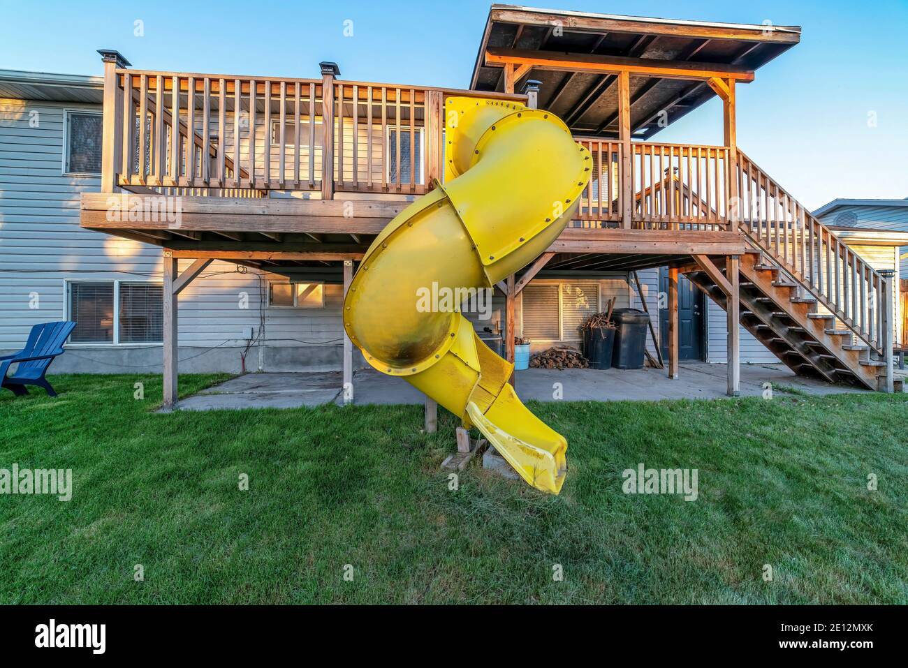 Maison avec toboggan jaune et escaliers sur la terrasse jusqu'à la cour  herbeuse Photo Stock - Alamy