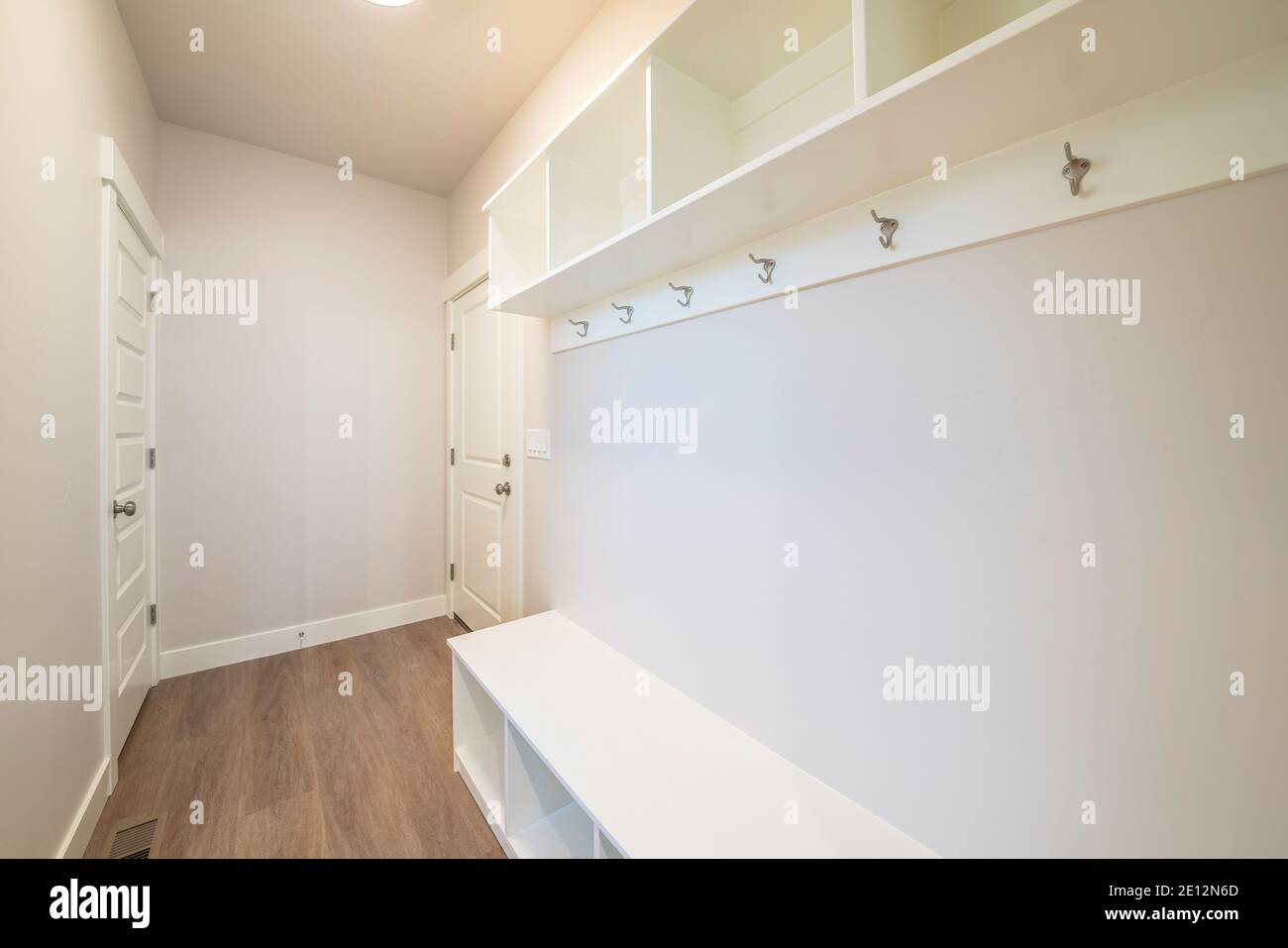 Chambre vide à l'intérieur d'une maison avec parquet intégré crochets d'étagères et deux portes Banque D'Images