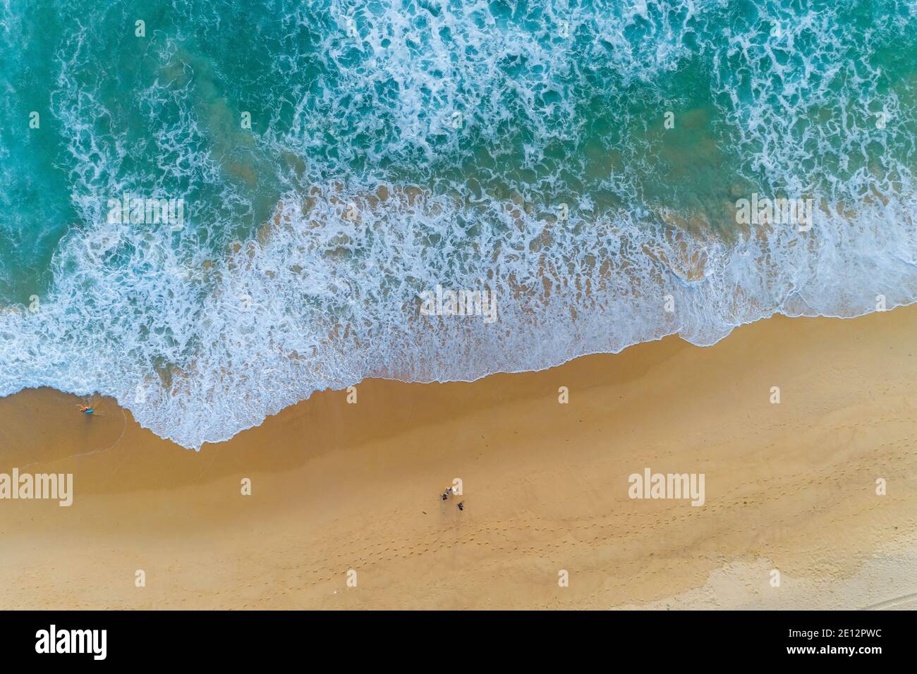 Vue incroyable vue aérienne caméra drone photo des vagues s'écrasant sur la rive sablonneuse, vue de dessus de la belle plage de sable au lever du soleil du matin. Banque D'Images