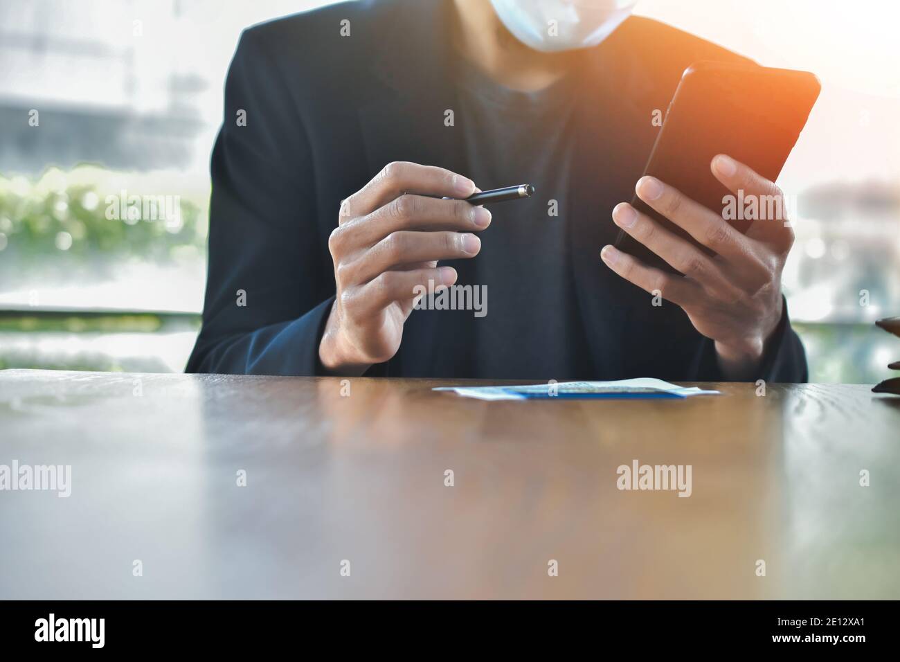 Homme d'affaires sous masque en utilisant un smartphone mobile pour travailler en ligne concentrez-vous Banque D'Images