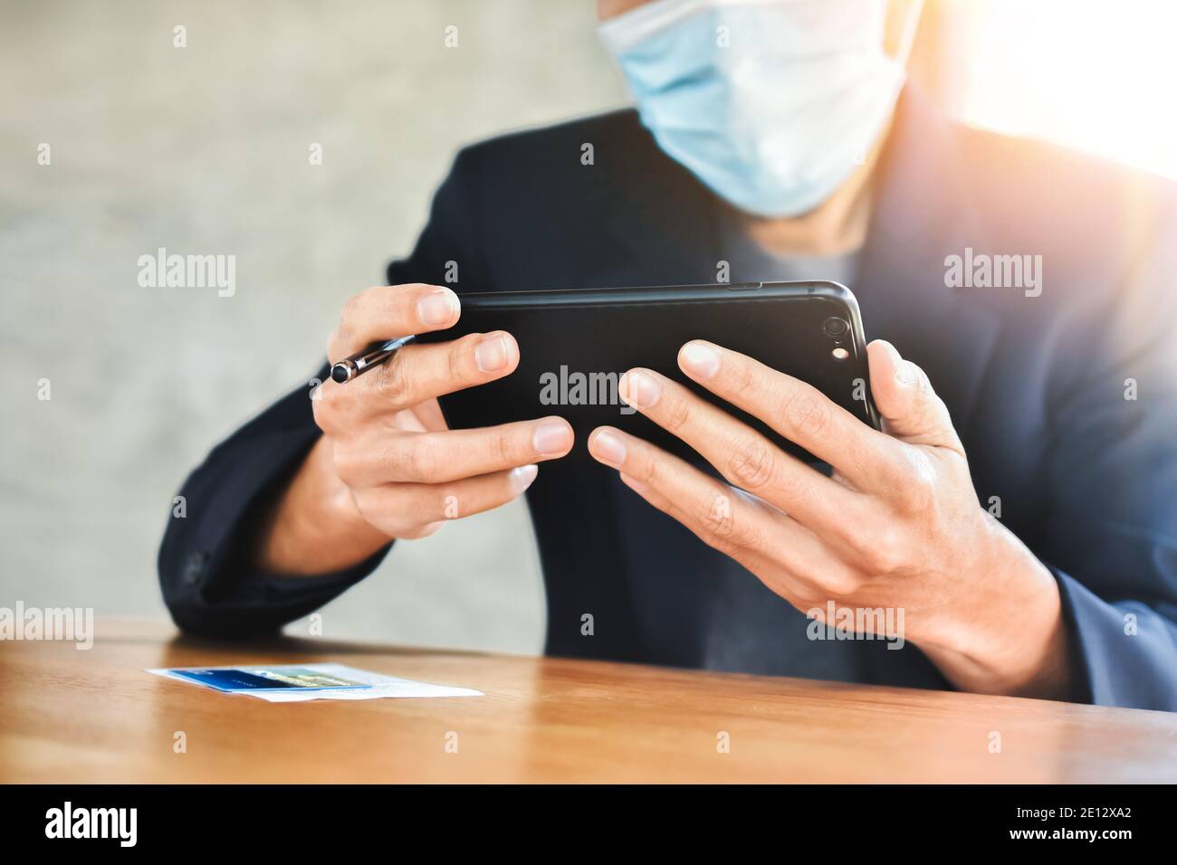 Homme d'affaires sous masque en utilisant un smartphone mobile pour travailler en ligne concentrez-vous Banque D'Images