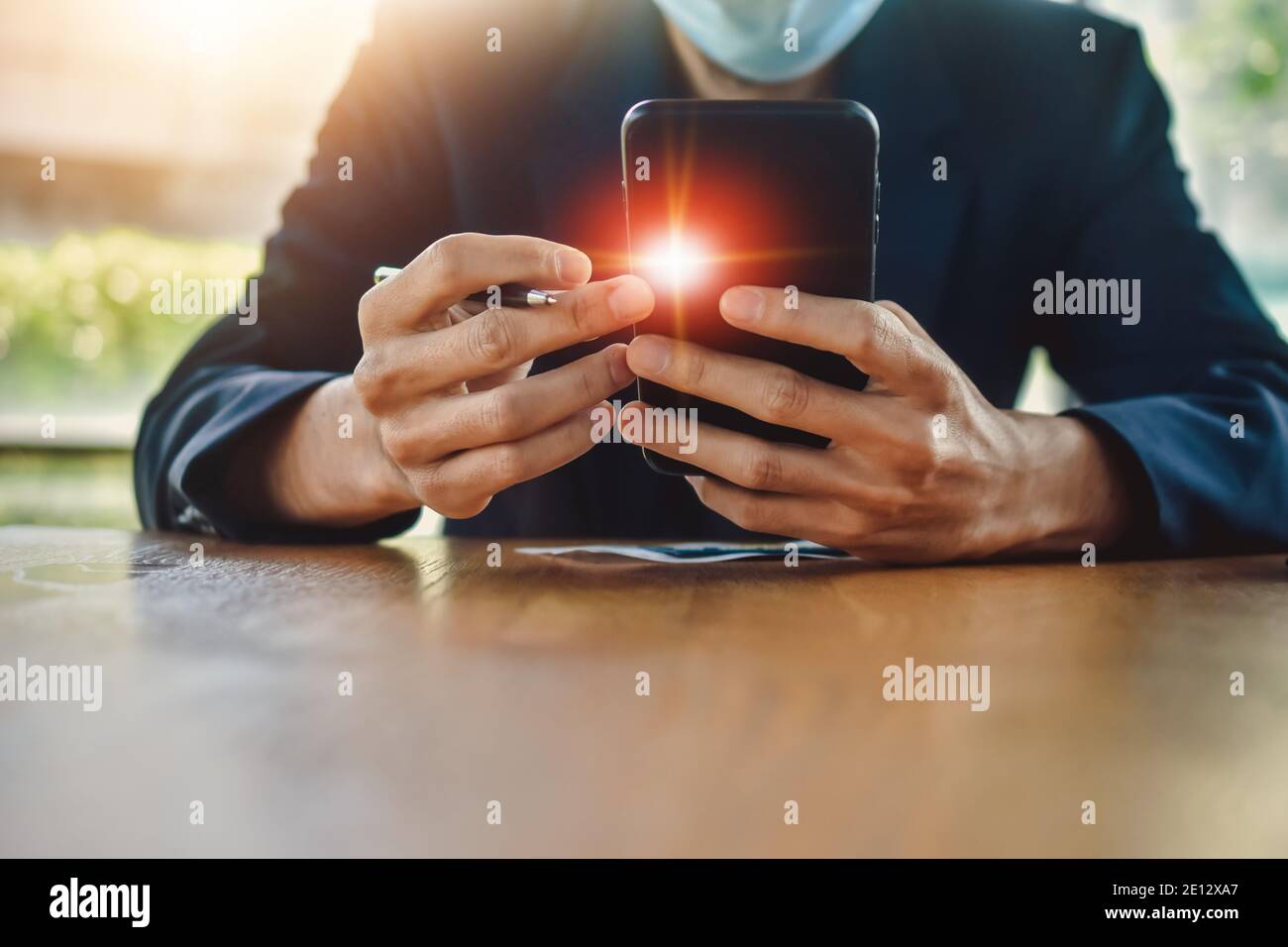Homme d'affaires sous masque en utilisant un smartphone mobile pour travailler en ligne concentrez-vous Banque D'Images