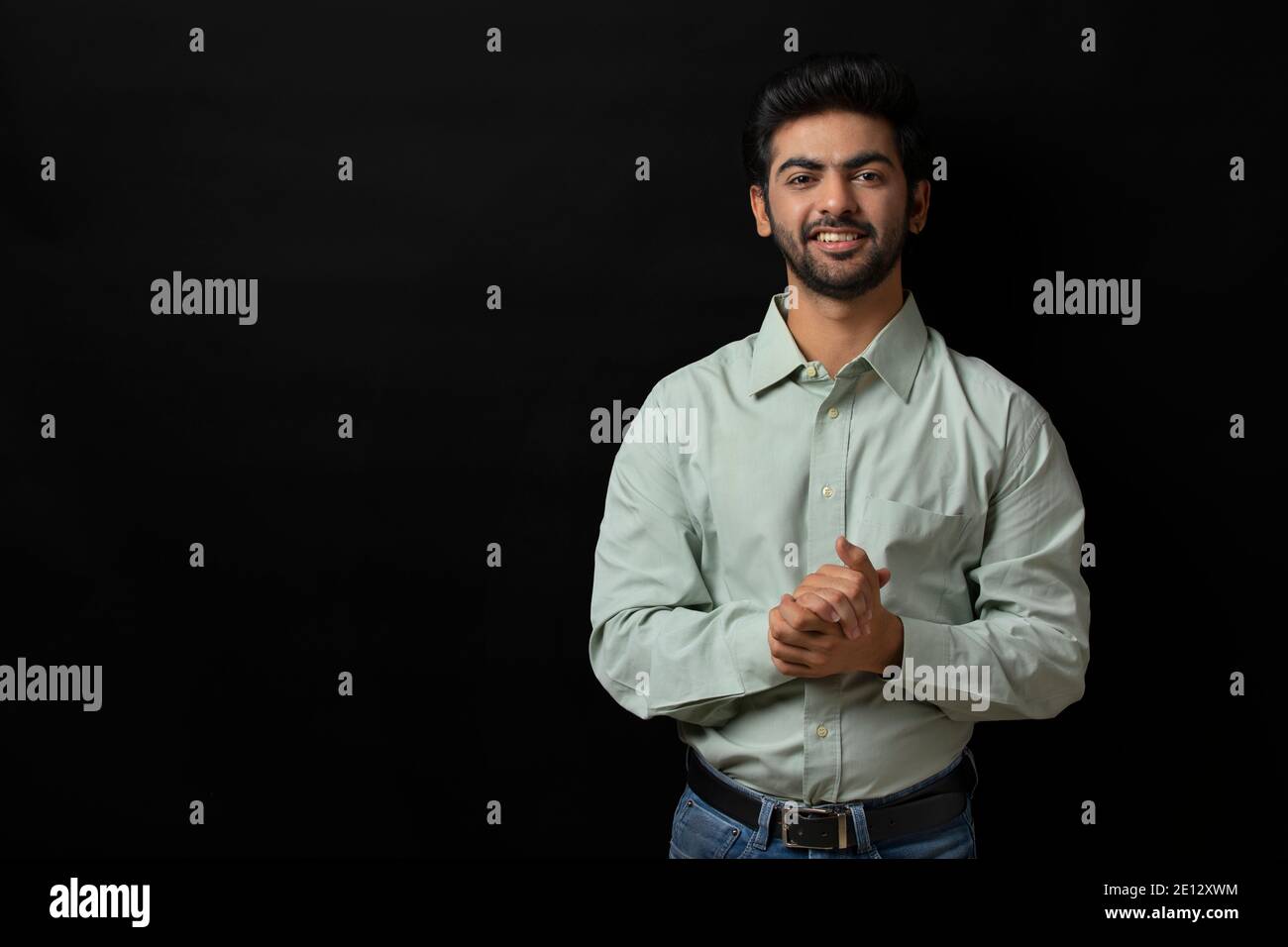 UN JEUNE CADRE SE FAIT UN PLAISIR DE REGARDER L'APPAREIL PHOTO ET DE SOURIRE Banque D'Images