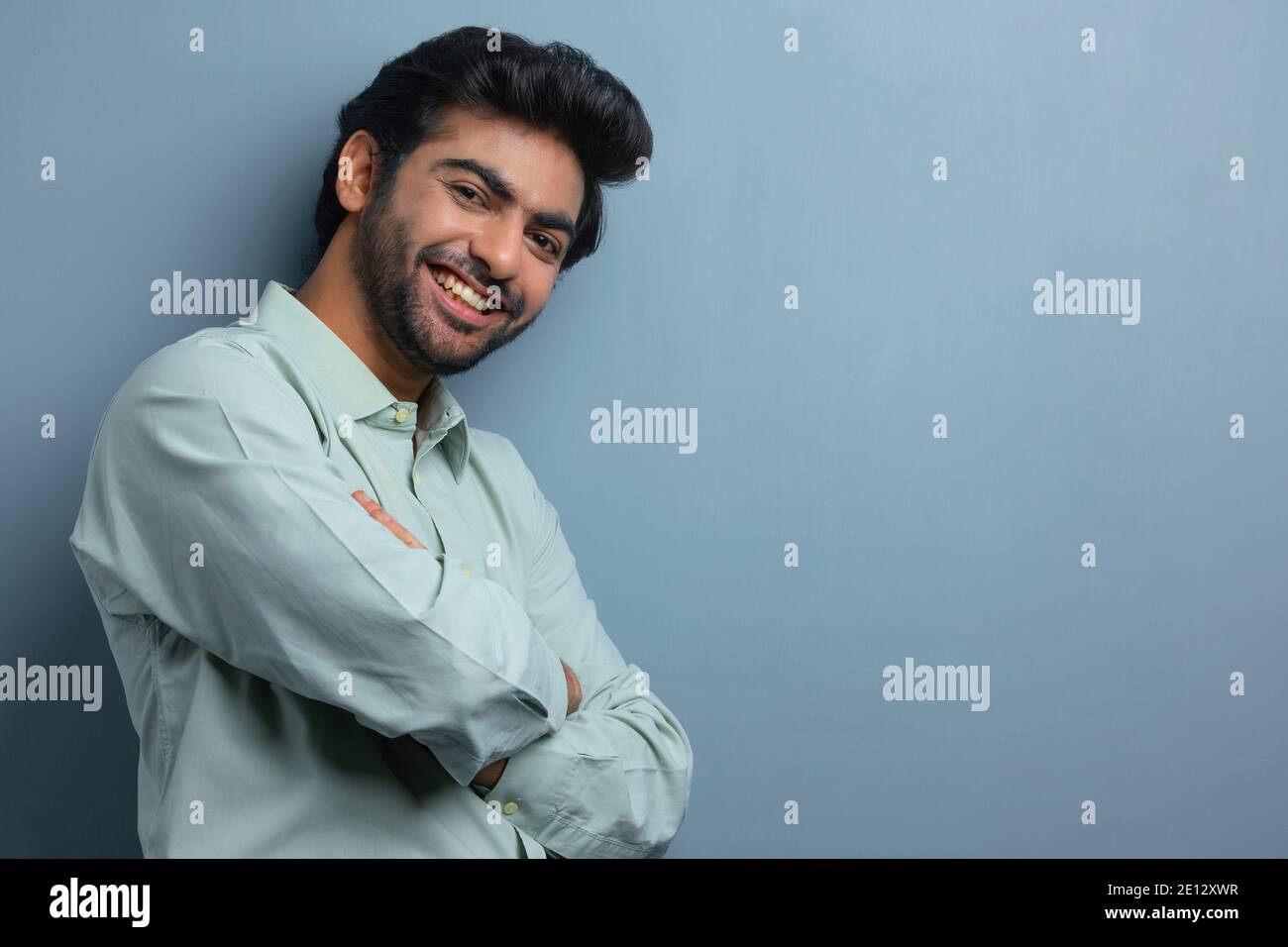 UN CADRE DE BUREAU SE TIENT DEBOUT ET SOURIANT À LA CAMÉRA Banque D'Images