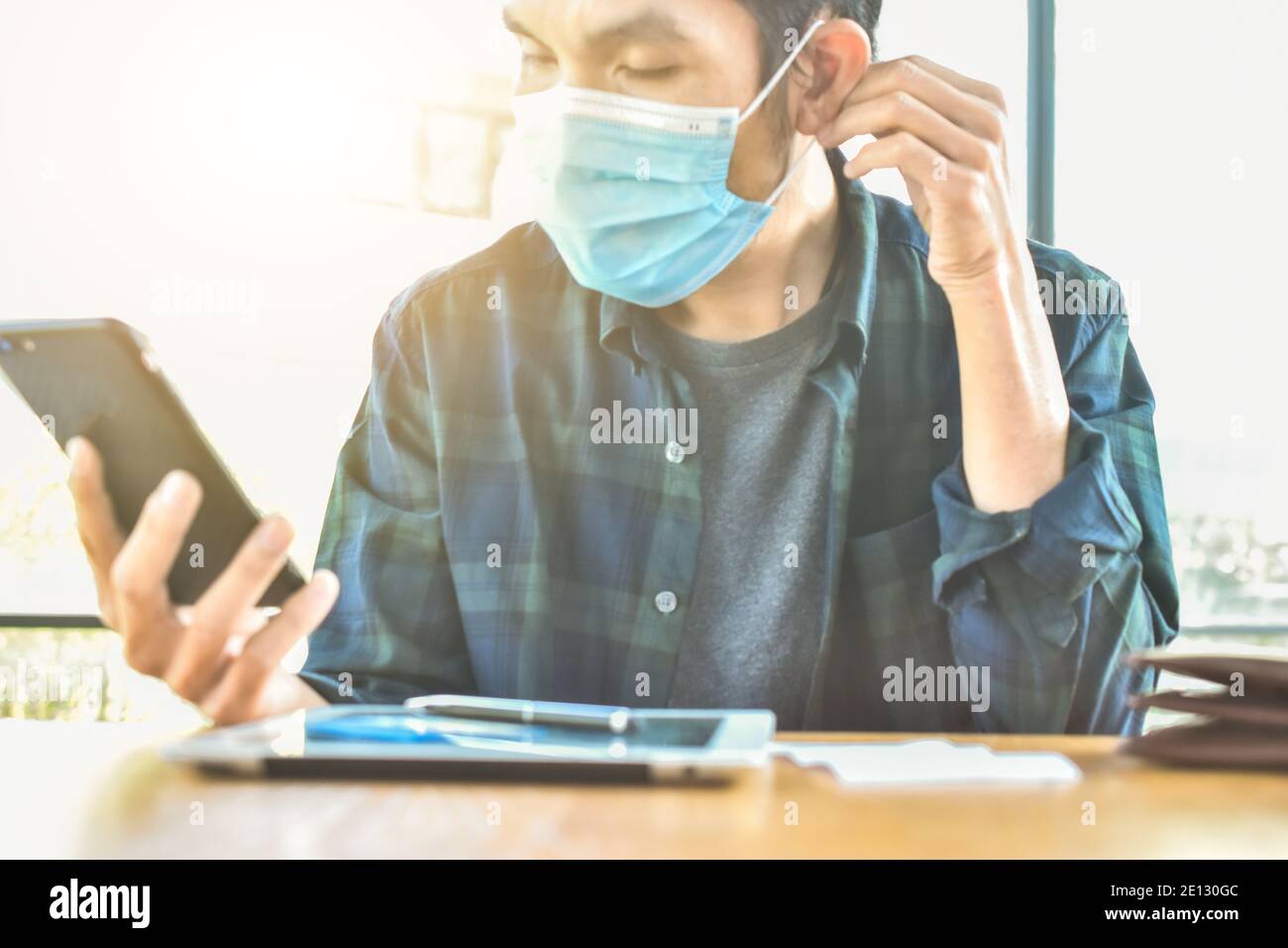 Focus sur le masque, homme asiatique port masque de visage dans le bureau protéger le coronavirus covid 19 Banque D'Images