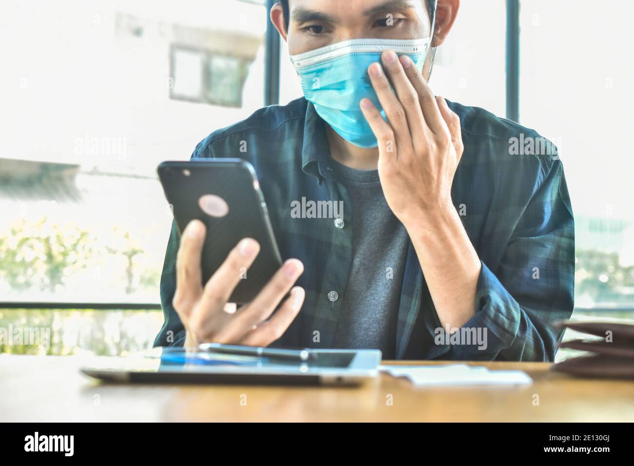 Focus sur le masque, homme asiatique port masque de visage dans le bureau protéger le coronavirus covid 19 Banque D'Images