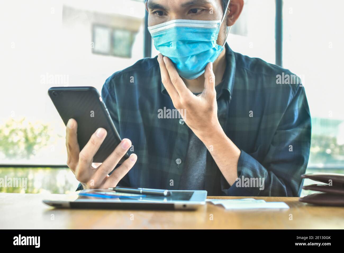 Focus sur le masque, homme asiatique port masque de visage dans le bureau protéger le coronavirus covid 19 Banque D'Images