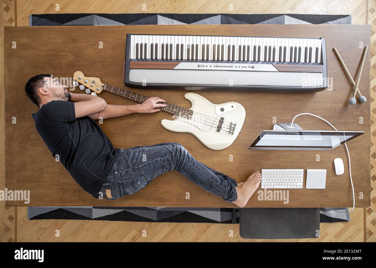 Composition avec vue de dessus avec instruments de musique sur une grande table en bois et un homme. Concept de créativité musicale. Banque D'Images