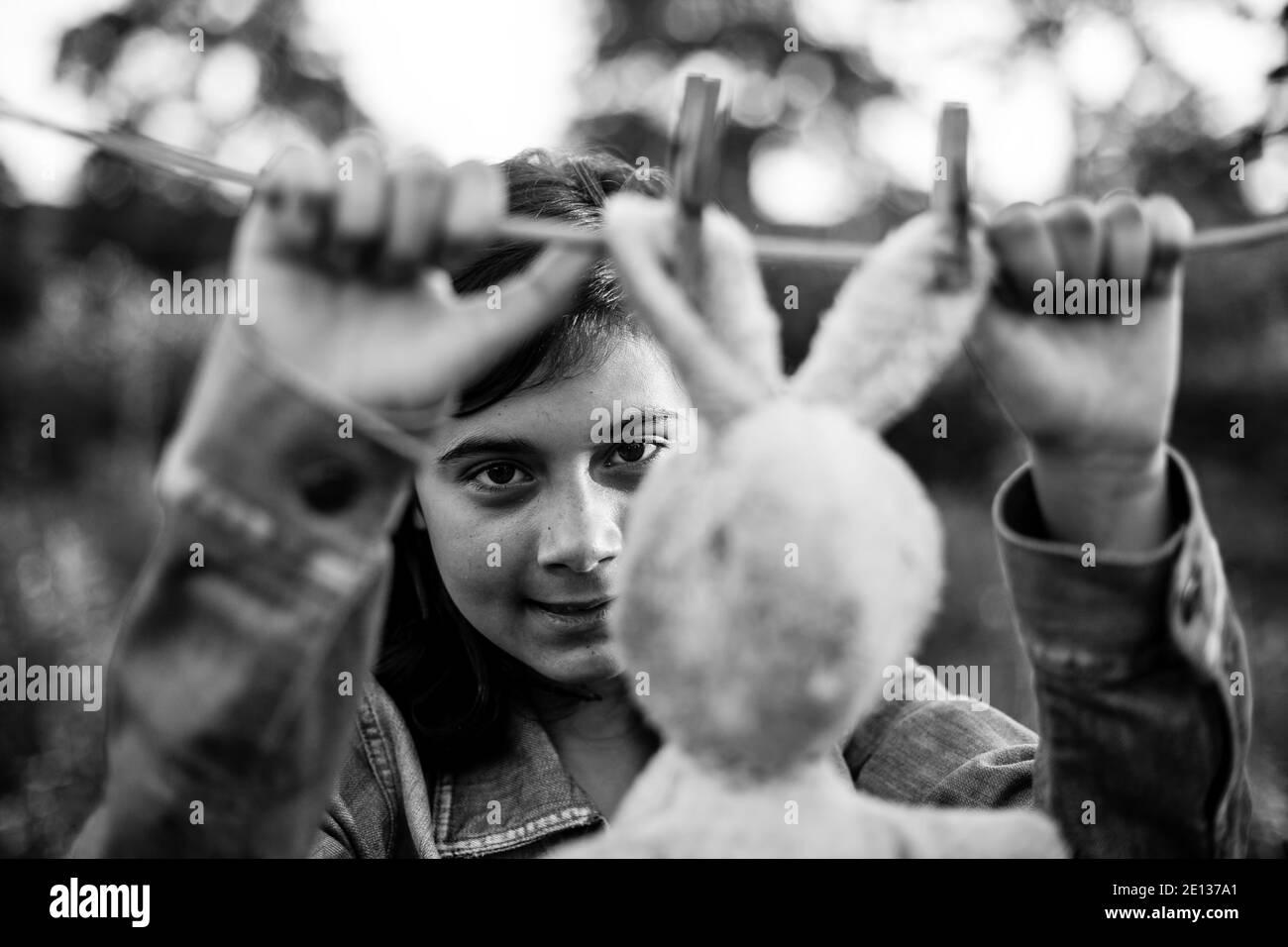 Une jeune fille sèche un lièvre sur une corde à linge. Photo en noir et blanc. Banque D'Images