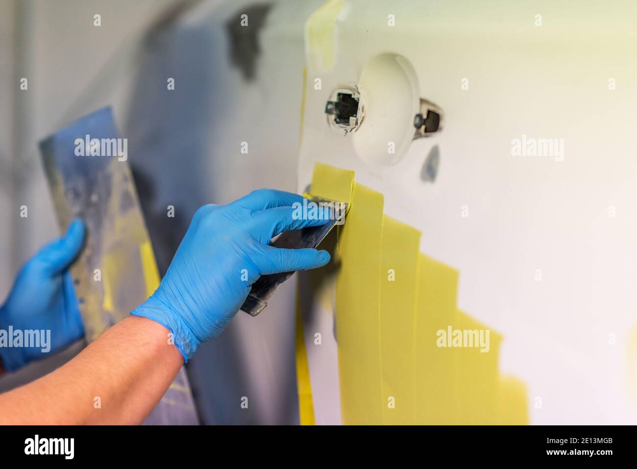 Préparation pour la peinture d'une voiture à l'aide de l'élément capteur d'émeri par un technicien de nivellement avant l'application d'un primaire après l'endommagement d'une partie de la Banque D'Images