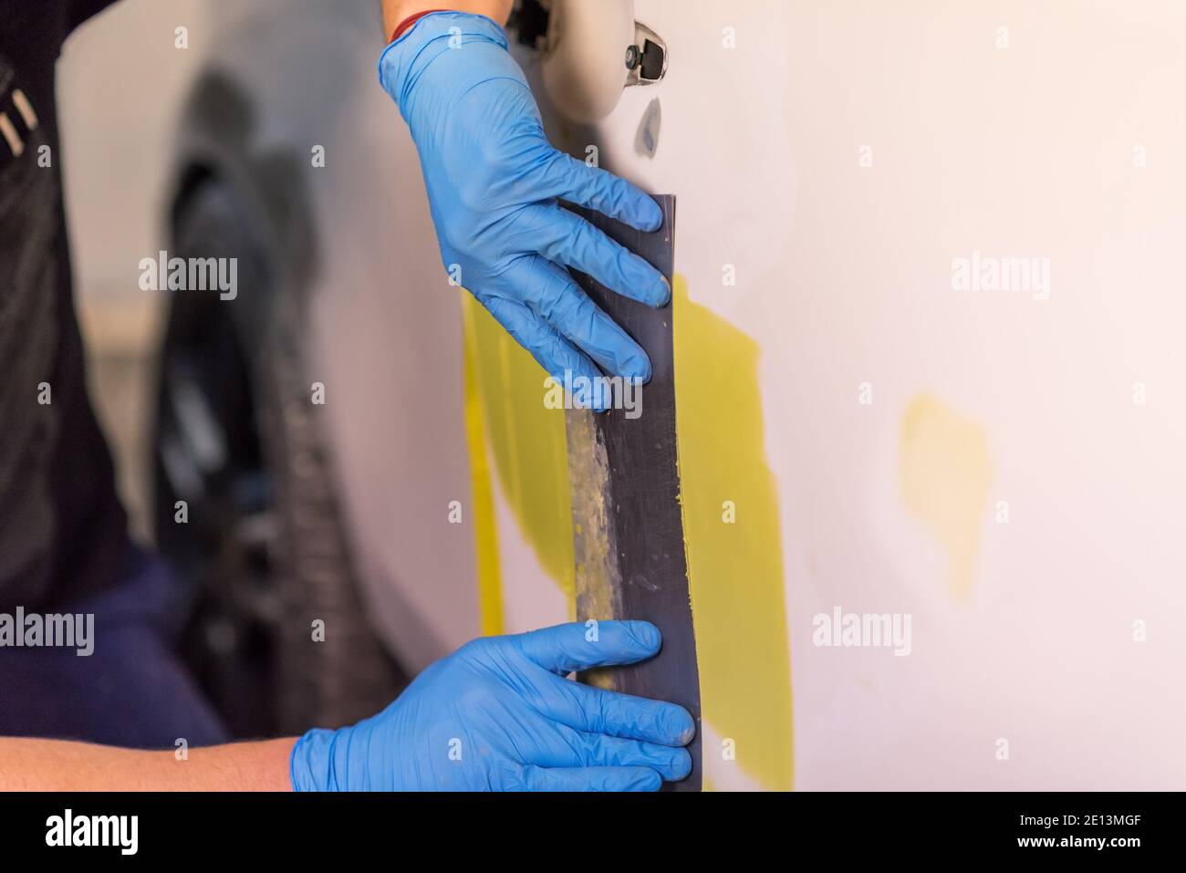 Préparation pour la peinture d'une voiture à l'aide de l'élément capteur d'émeri par un technicien de nivellement avant l'application d'un primaire après l'endommagement d'une partie de la Banque D'Images