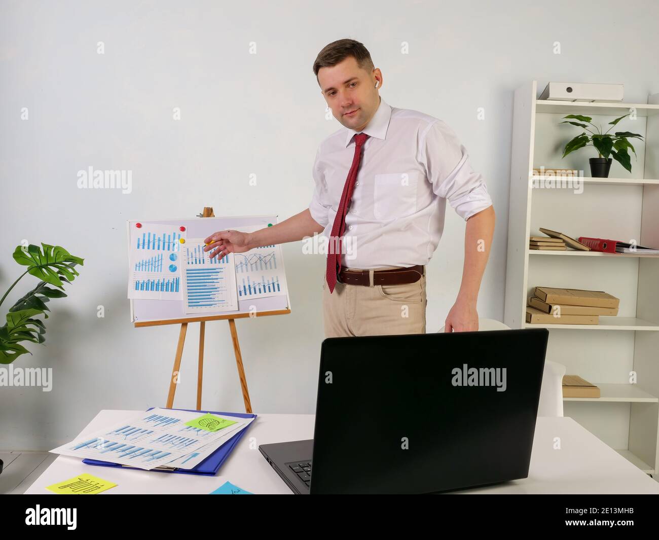 Présentation commerciale en ligne sur Internet. Un homme communique avec ses collègues avec un ordinateur portable. Banque D'Images
