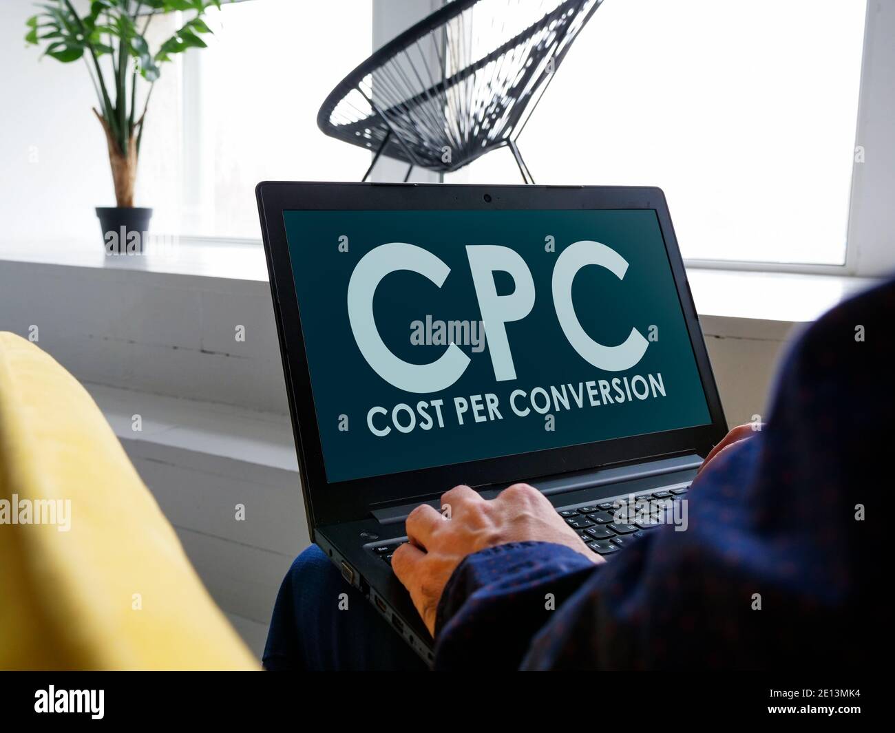 Un homme lit au sujet du coût par conversion CPC sur l'Internet. Banque D'Images