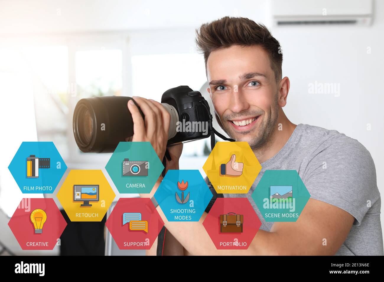 Jeune homme avec caméra en studio. Mentorat pour les photographes Banque D'Images