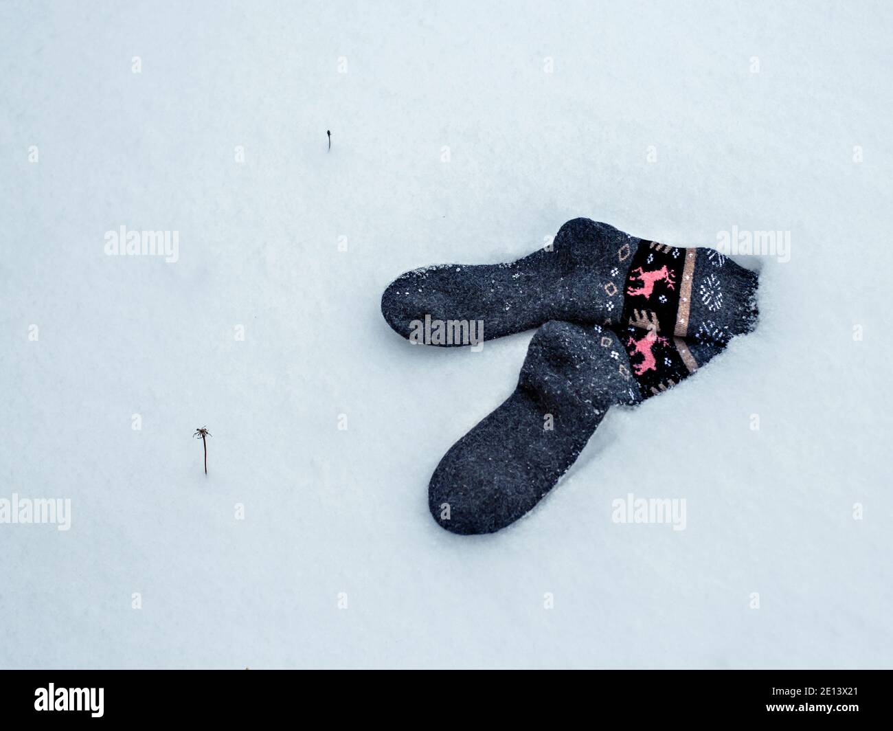 Des chaussettes chaudes en laine avec ornement reposent sur la neige blanche. Mise au point sélective Banque D'Images