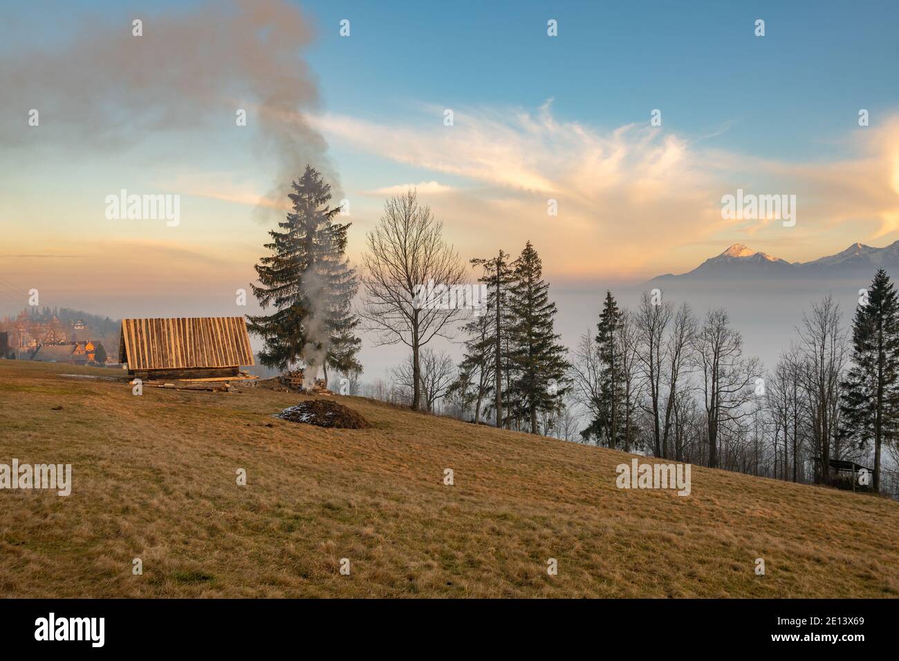 Une cabane de berger sur une pente de montagne et une brûlante incendie Banque D'Images