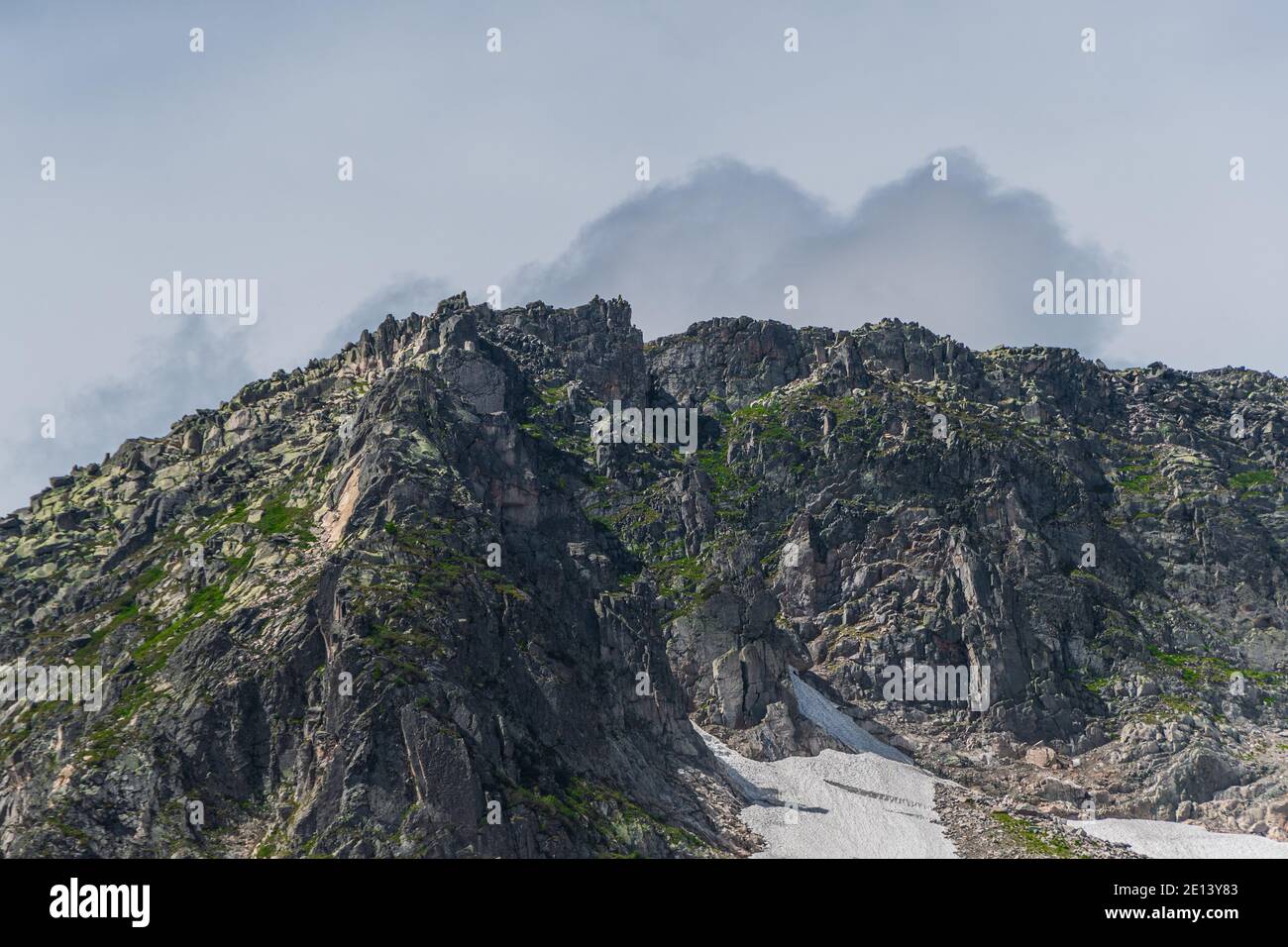 Vallée de montagne avec crête en pierre et arbres à l'horizon. Traversez les rochers sauvages en été. Paysage de montagne par rapport au ciel bleu le jour ensoleillé Banque D'Images