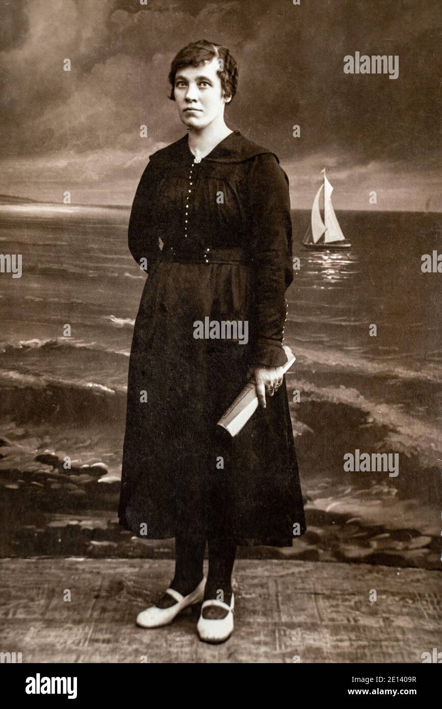 RUSSIE - VERS les années 1920 : photo du corps entier des femmes en studio Vintage carte de Viste Edwardian Era. Mer peinte avec arrière-plan de bateau à voile Banque D'Images