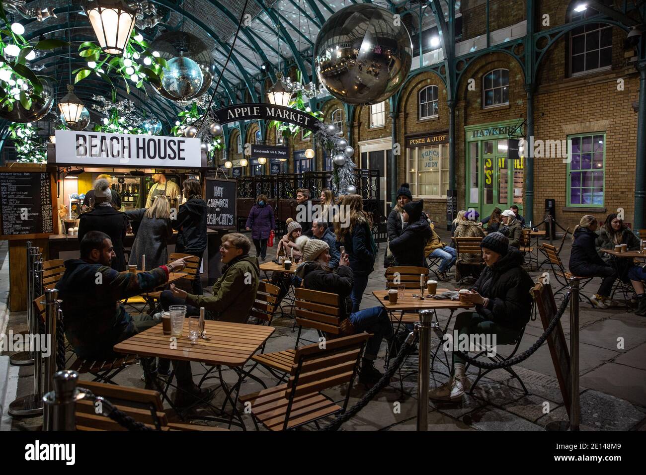 Les amateurs de Noël s'assoient et prennent un café socialement distancé sur la Covent Garden Piazza lors des mesures de verrouillage du coronavirus Tier2, Londres, Royaume-Uni Banque D'Images