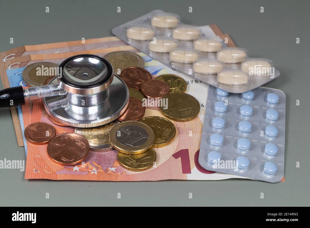 Stéthoscope noir, paquet de pilules, pièces en euros et billets de banque comme concept pour le prix des traitements médicaux Banque D'Images