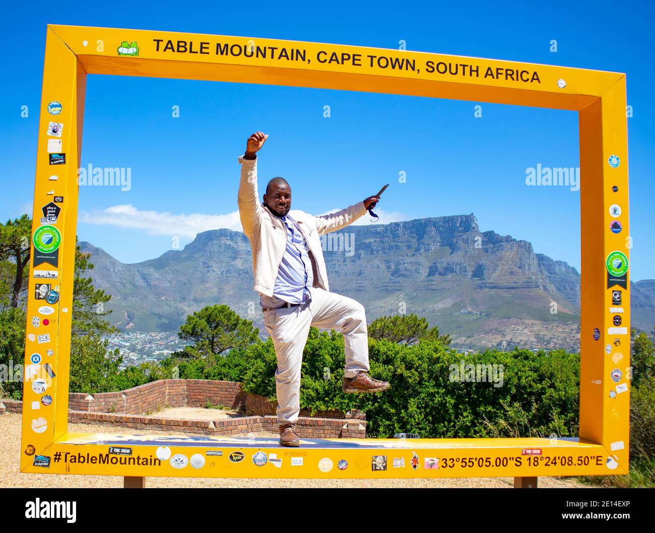 Signal Hill - Cape Town, Afrique du Sud - 12-02-2020 Homme debout dans le cadre jaune de Table Mountain. Des poses amusantes frappantes. Banque D'Images