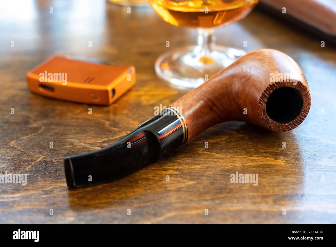 Pipe de tabac sur une table en bois, vue rapprochée. Tuyau fait à la main en bois de verre de brandy et plus léger, fumer et boire plaisir Banque D'Images